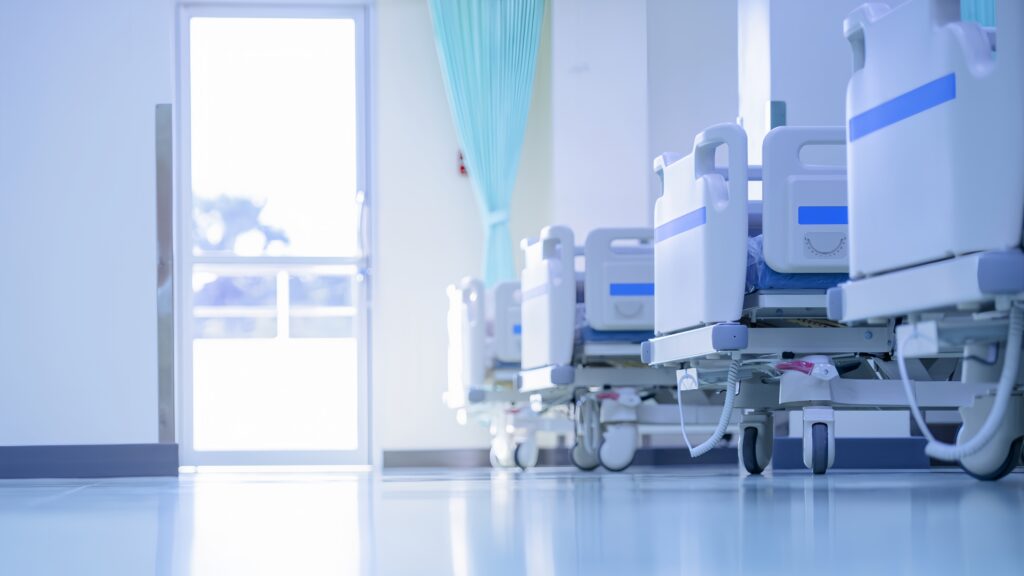 Row of modern electric hospital beds in a bright ward